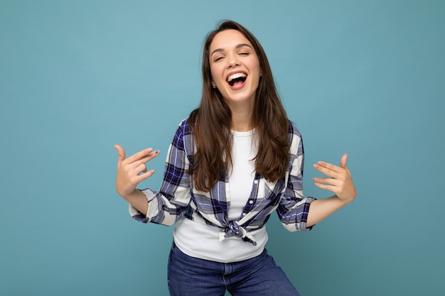 Shot of young positive smiling beautiful brunette woman with sincere emotions wearing trendy check