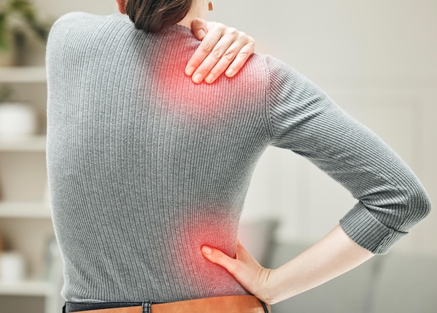 Shoulder hip and back pain of a woman touching and holding a painful area on her body in red Closeup of a female feeling strain ache and discomfort from a glowing muscle injury problem