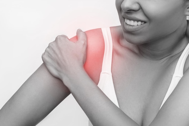 Shoulder injuries. Cropped shot of young caucasian woman holding shoulder in her hand. Joint disease