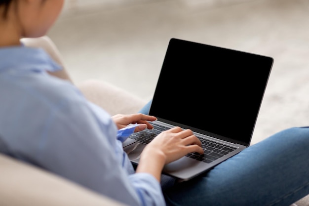 Over shoulder shot of woman using laptop mockup