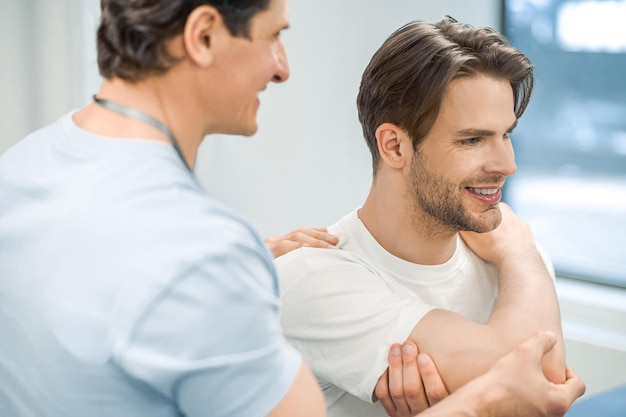 Shoulderjoint rehabilitation Manual therapist helping patient to work out the shoulder joint