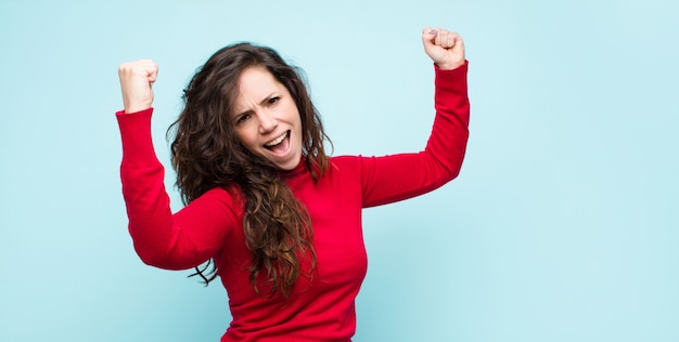 shouting triumphantly, looking like excited, happy and surprised winner, celebrating