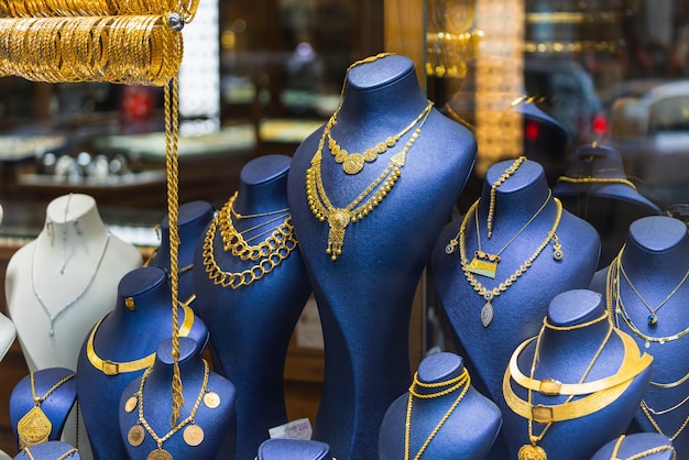 Showcase of a jewelry store with a huge selection of gold jewelry bracelets chains rings and earrings on a female relief