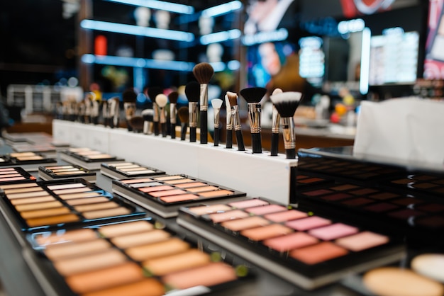 Showcase with powder and shadows in cosmetics store, nobody. Luxury beauty shop, shelf with products in fashion market