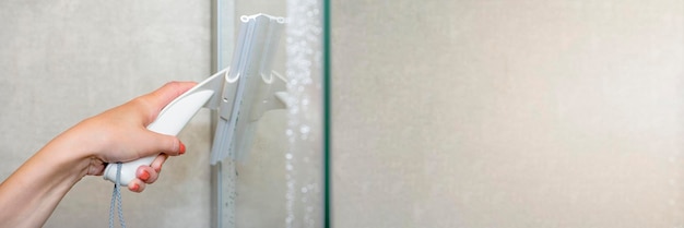 Shower cabin cleaning Cleaning glass after using the shower Cleaning glass with a rubber scraper