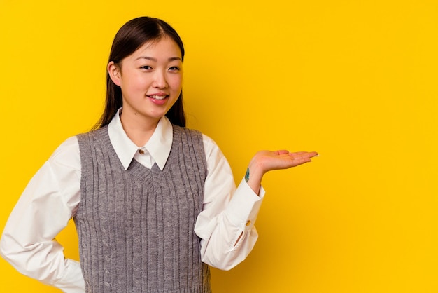 Showing a copy space on a palm and holding another hand on waist