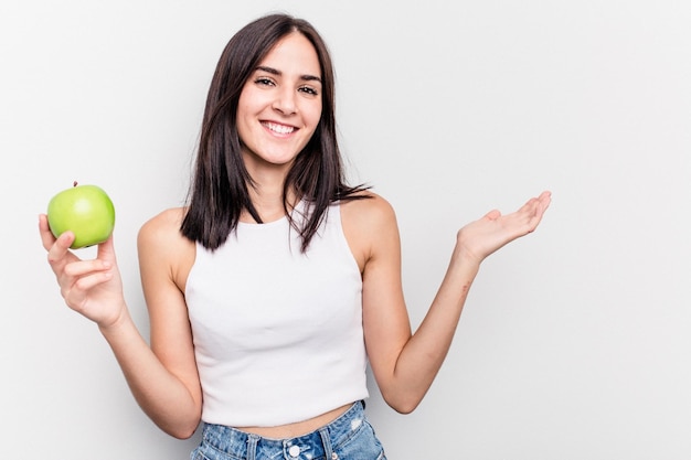 Showing a copy space on a palm and holding another hand on waist