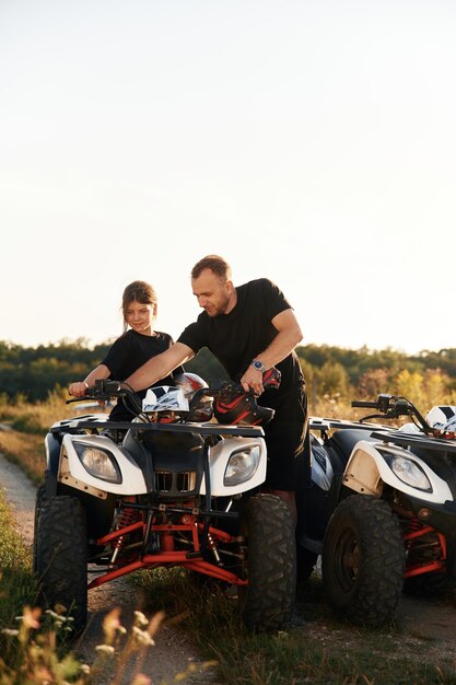 Photo showing how the machine works father and daughter are with atv outdoors