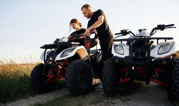 Photo showing how the machine works father and daughter are with atv outdoors