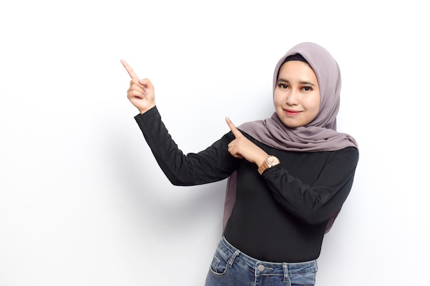 Showing and pointing left side copyspace of Young beautiful muslim asian women