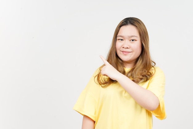 Showing Product and Pointing Side of Beautiful Asian Woman wearing yellow TShirt Isolated On White