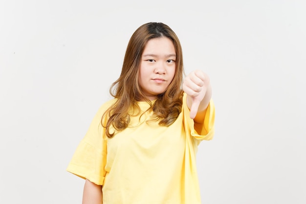 Showing thumbs down of Beautiful Asian Woman wearing yellow TShirt Isolated On White Background