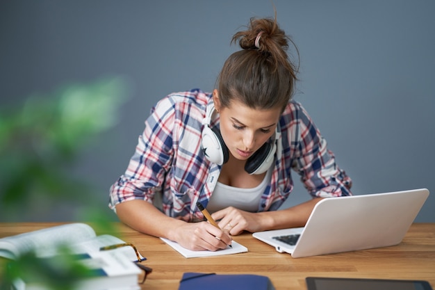 showing tired female student learning late at home