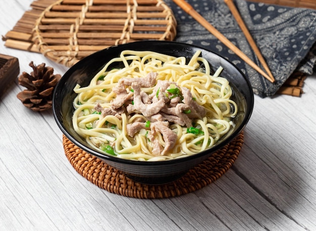 Shredded Pork Noodle Soup in a dish isolated on wood table side view taiwan food