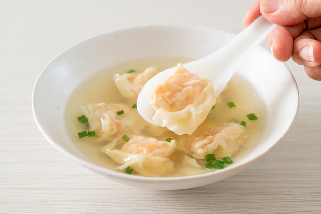 Shrimp dumpling soup in white bowl