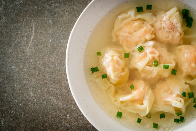 Shrimp dumpling soup in white bowl