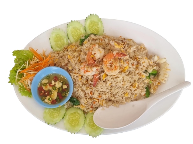 or Shrimp fried rice in a white plate with cucumber lettuce and carrots Served with fish sauce mixed with fresh chili isolate white background