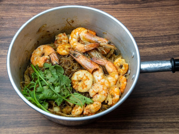 Shrimp potted with vermicelli or glass noodles on wooden table