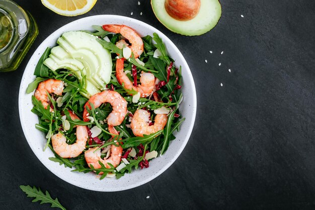 Shrimp salad with fresh green arugula leaves and avocado radicchio almond and sesame seeds Healthy lunch bowl salad