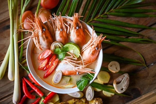 Shrimp soup on seafood soup bowl with thai herb and spices Thai Food Tom Yum Kung Hot and sour spicy shrimps prawns soup curry lemon lime galangal red chili straw mushroom on table food