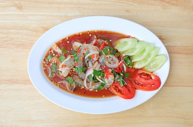 Shrimp spicy salad in dish on wood table background