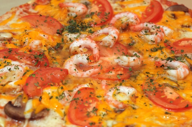 A shrimp and tomato pizza with cheese and herbs.