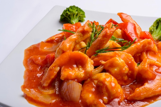 Shrimp in tomato sauce on a white square plate Closeup Chinese food