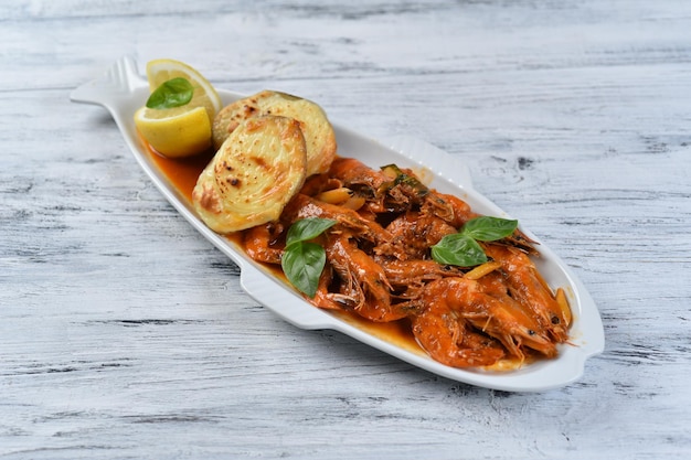 Shrimp with tomato sauce and baked potatoes, seafood platter,  top view