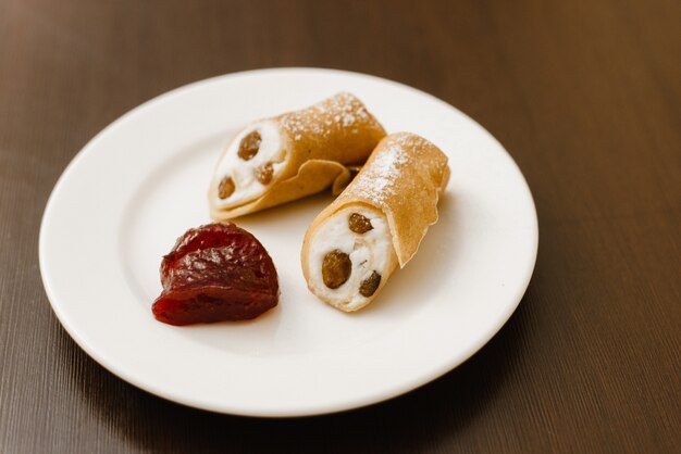 Shrovetide Maslenitsa Butter Week festival meal.  A pair of Russian pancakes with orange jam on a dark table. Traditional Pancake week.Rustic style, top view close-up