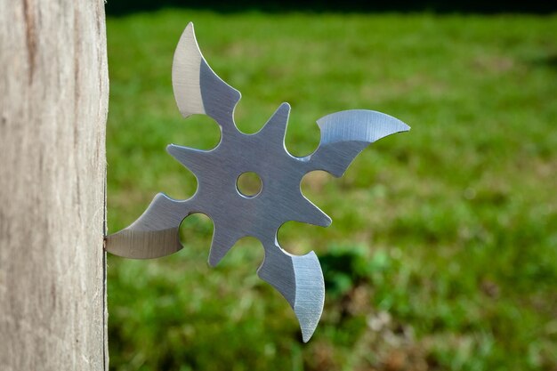 Shuriken throwing star traditional japanese ninja cold weapon stuck in wooden background