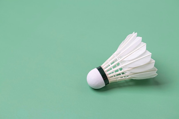 Shuttlecock badminton on green background with copy space