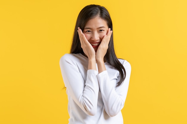 Shy asian woman in casual dress covering face and peeking