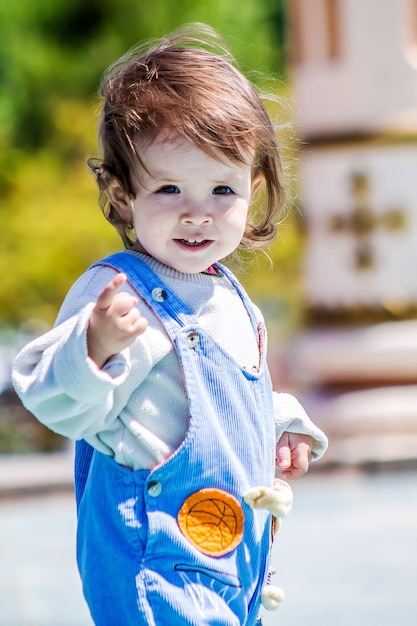 Shymkent Kazakhstan May 2 2018 A small child with long hair developing in the wind plays in the city park on a bright spring day