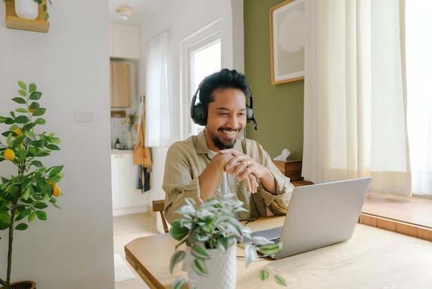 Photo sian man having video call meeting with team at home