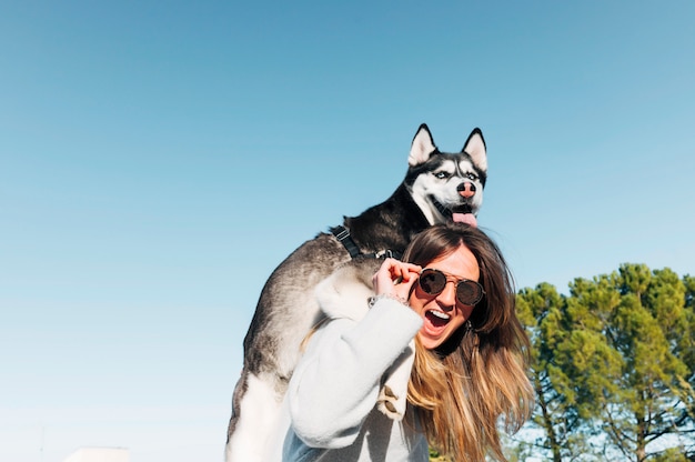 Siberian Husky dog posing on the man of beautiful blonde woman.