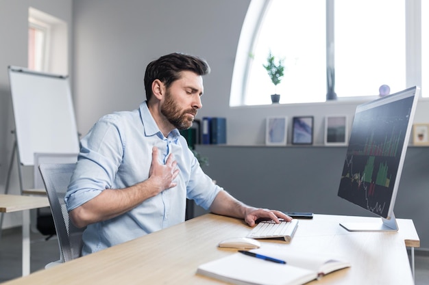 Sick businessman working in the office man worried and holding his hand to his chest severe heart pain