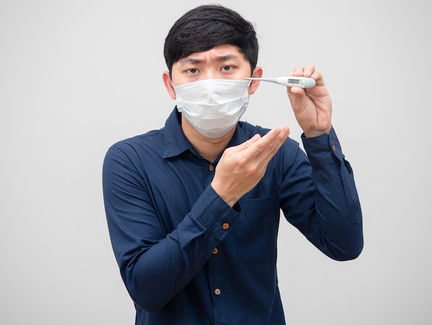 Sick man wearing mask show thermometer high temperature unwell face on white background