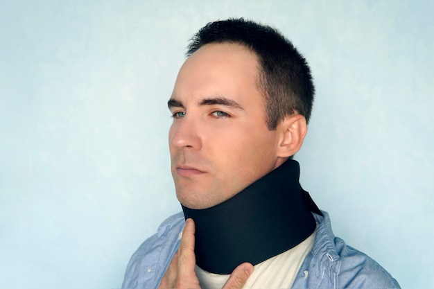 A sick man with a black collar to fix a neck fracture Medical cervical collar warm collar warming up the throat