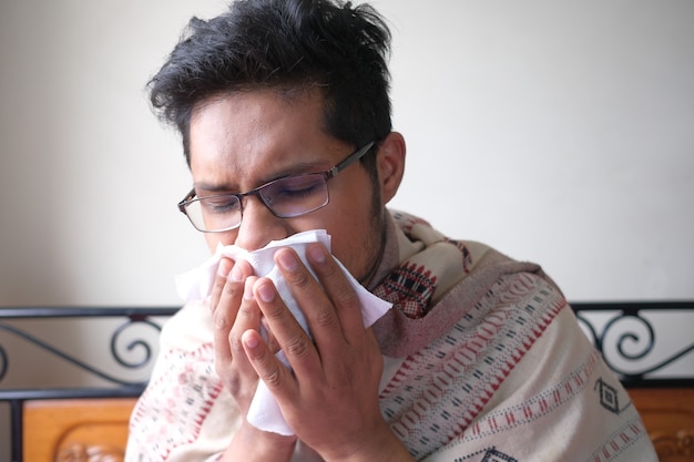 Sick man with flu blow nose with napkin