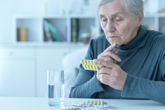 Sick senior woman taking medicine