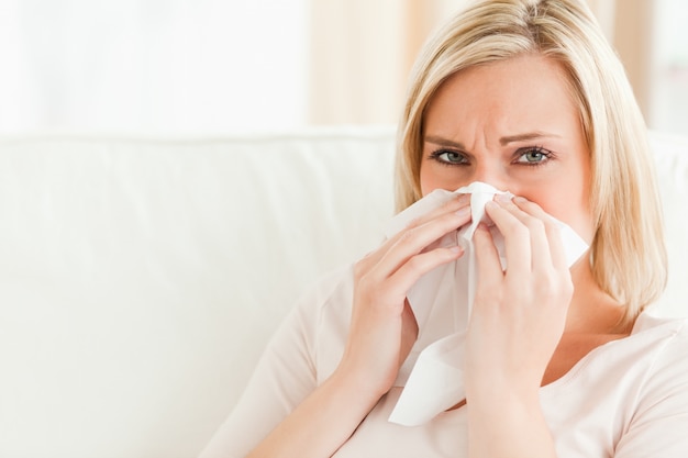 Sick woman blowing her nose