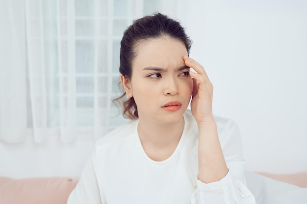 Sick woman covered with a blanket lying in bed with high fever and a flu resting