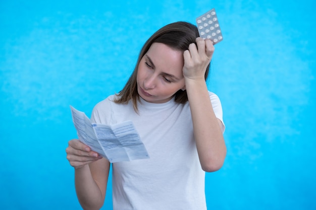 Sick woman looking at the explanation of the medicine before taking prescription medications