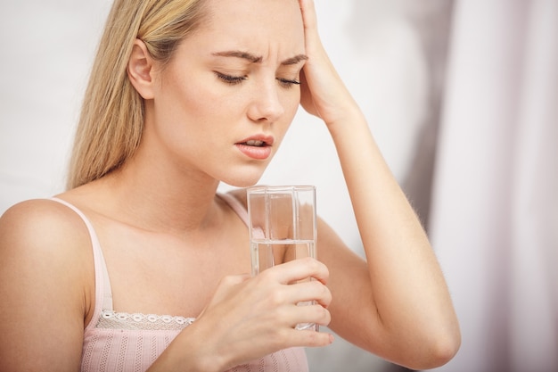 Sick woman lying in bed with high fever