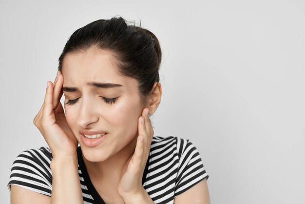 Sick woman in a striped tshirt pain in the neck isolated background High quality photo