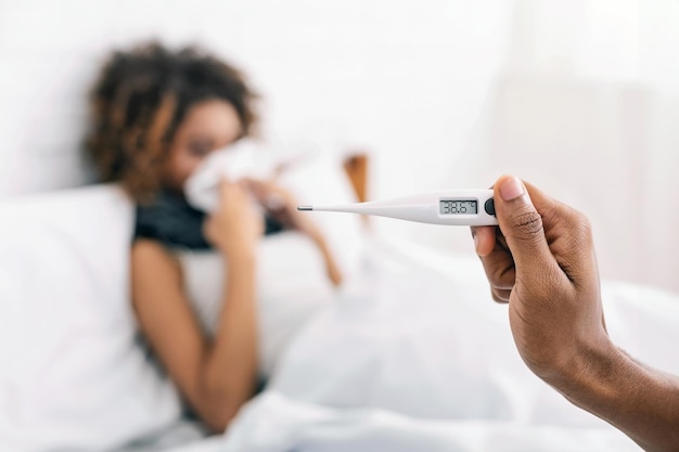 Sick woman with fever lying in bed