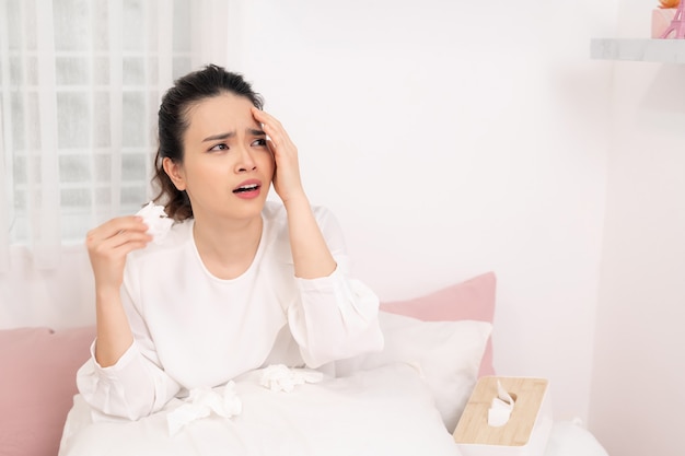 Sick woman with seasonal infections, flu, allergy lying in bed.