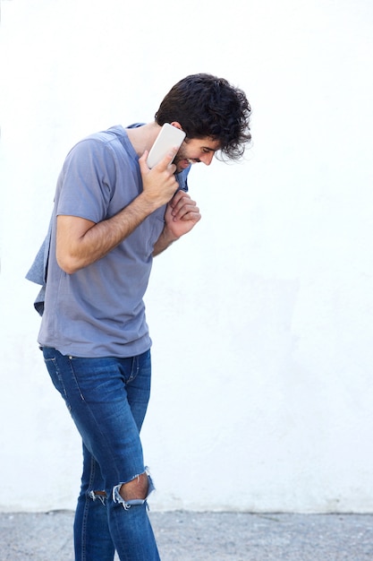 Side of happy man talking on mobile phone