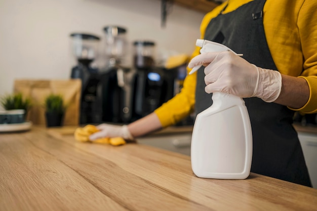 Side view of barista cleaning surface