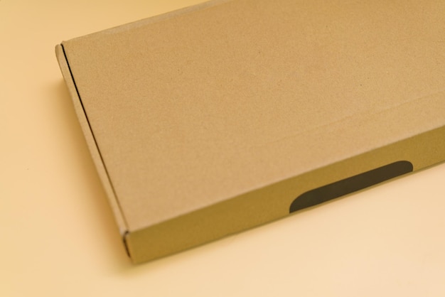 A side view of a brown paper box on an orange background Carrier Presentation Transportation Copy Space Fold Packing Mailing Single Ecological Distribution Courier Carrier Cargo